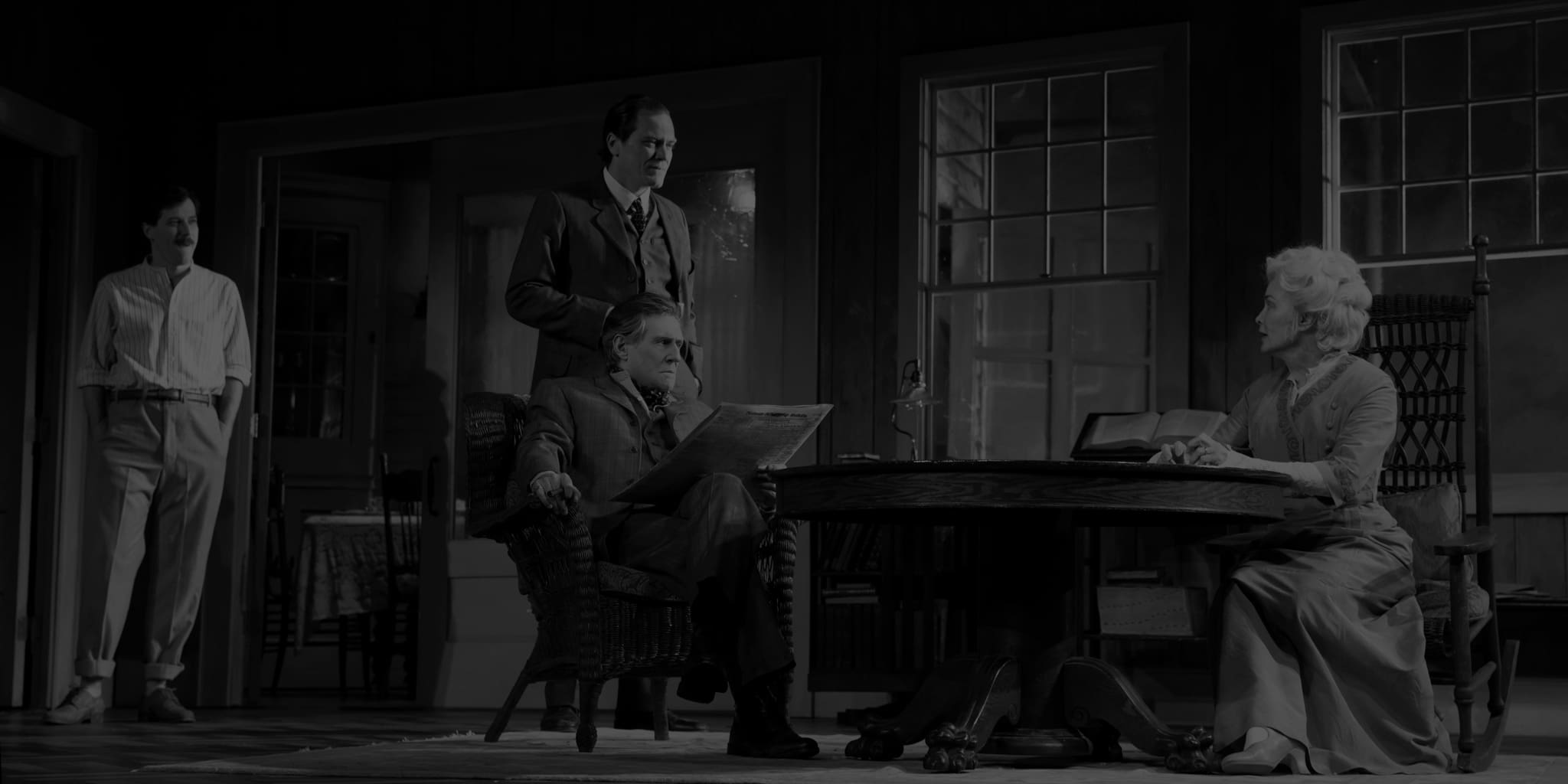 Production photo from LONG DAY'S JOURNEY INTO NIGHT. Four actors in 1910s clothing in a study. An old woman sits at a table with an older man, while two men stand behind him.