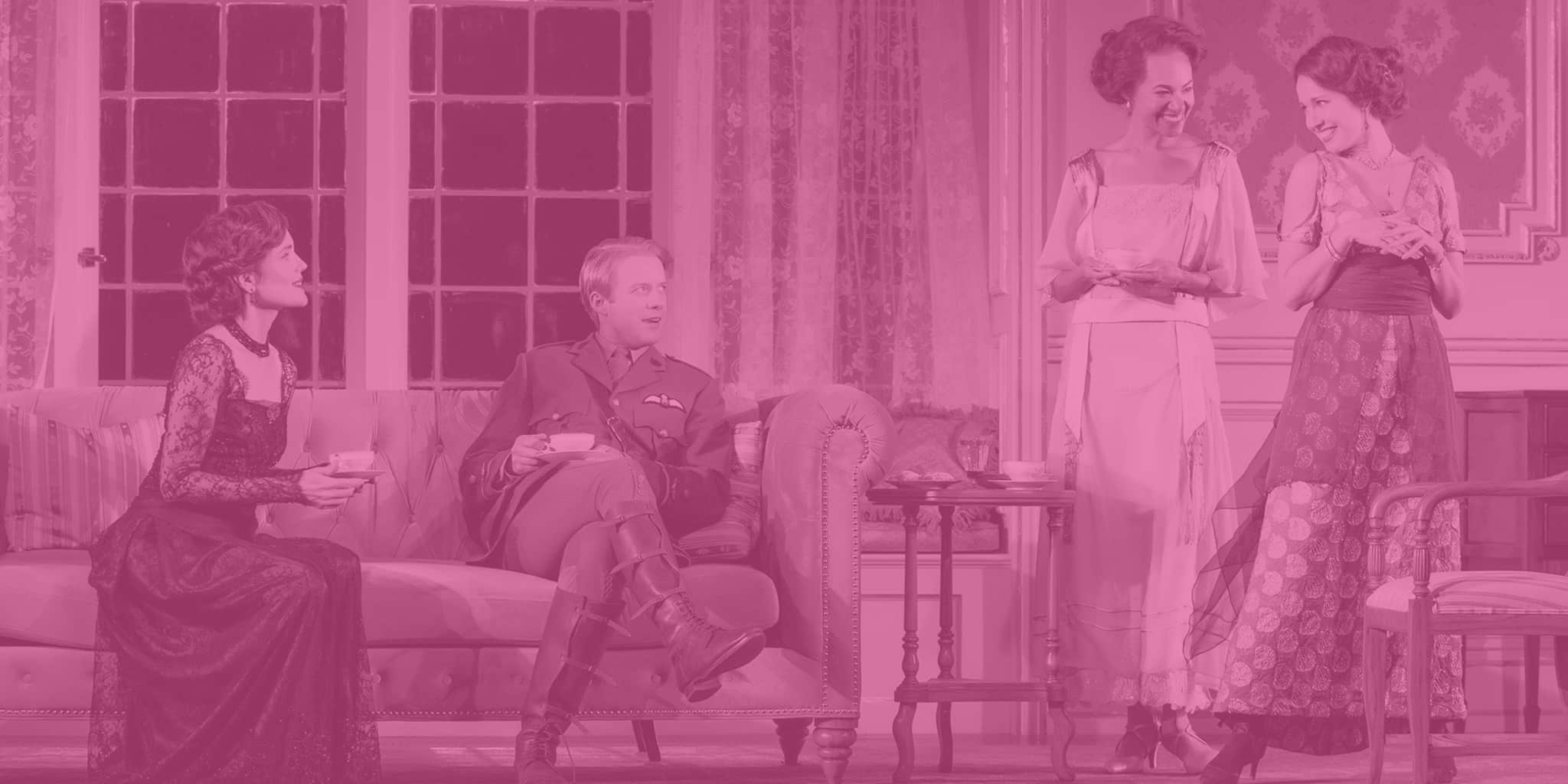 Four actors in a fancy living room holding tea cups. A woman in a lacy black and red dress sits on a sofa next to a military man. Two women with fancy up-do's swoon off to the side.