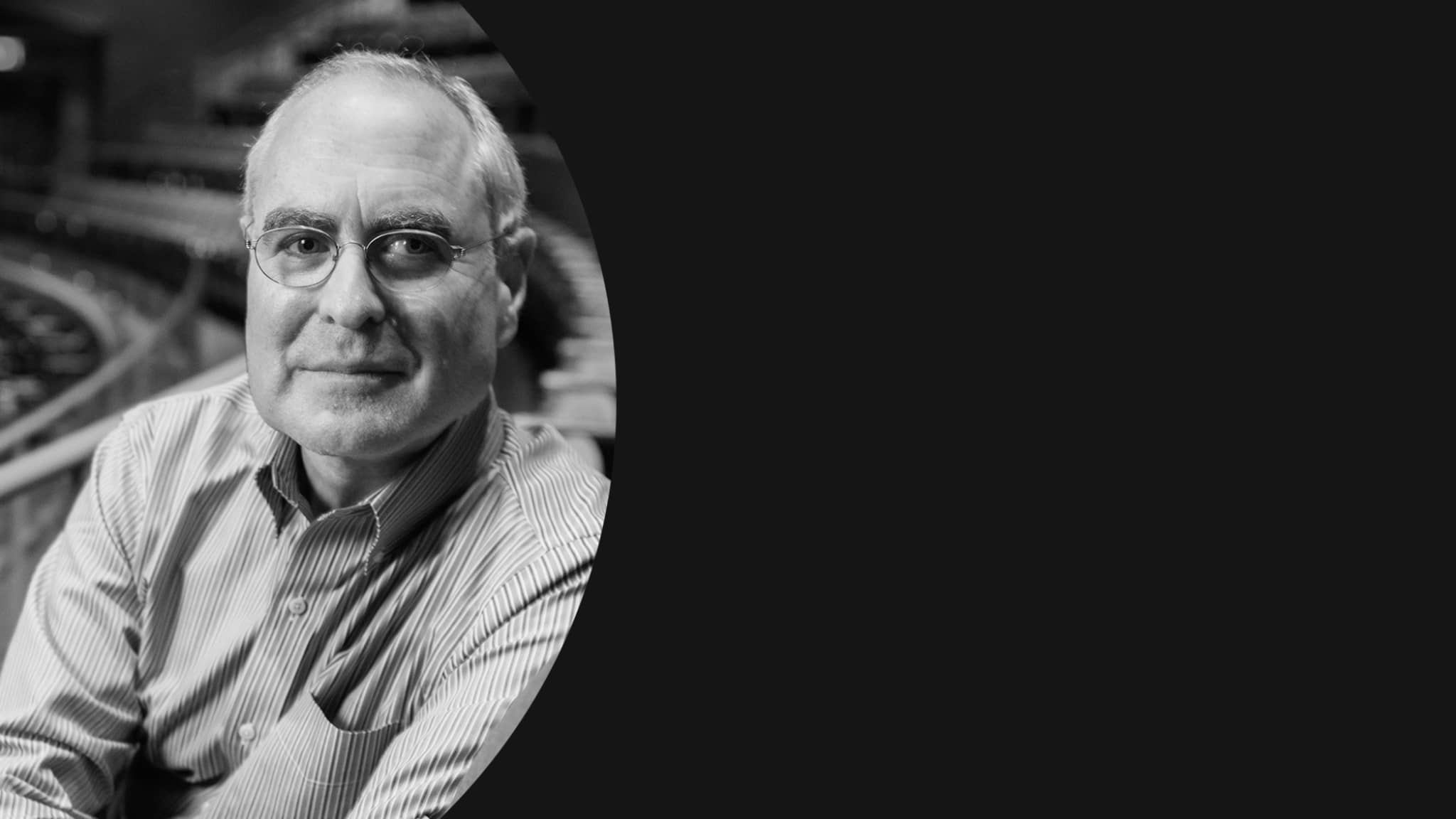 Black and white image of Todd Haimes sitting in an empty theatre.