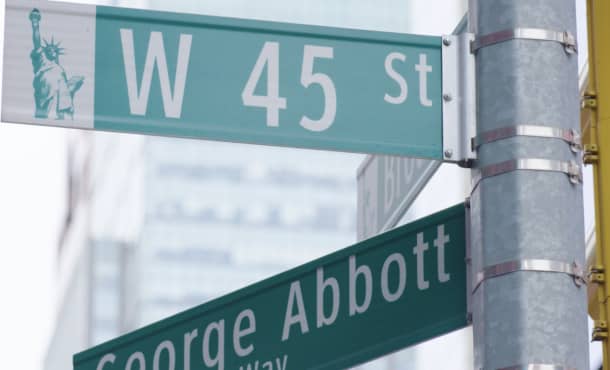 Green New York street signs showing the intersection of West 45th street and George Abbott Way.