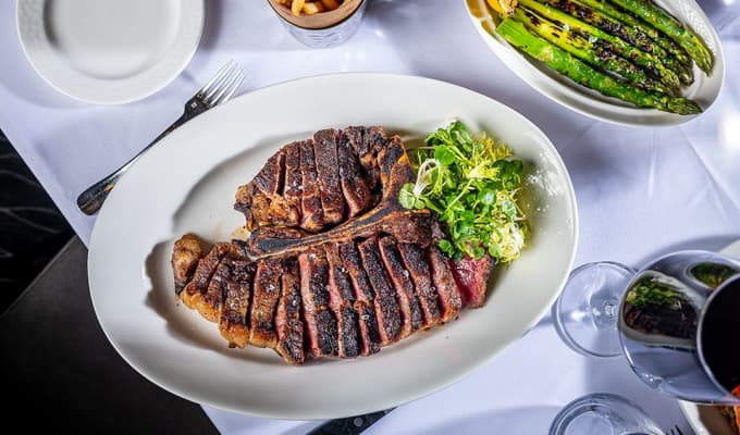 A plate with a large steak cut into slices.