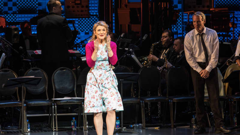 Victoria Clark blows a kiss at the audience during her bow. She wears a pink cardigan over a floral dress.