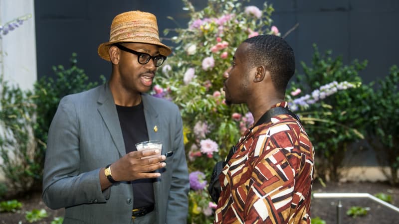 Eric Berryman holds a drink and talks to a theatregoer.