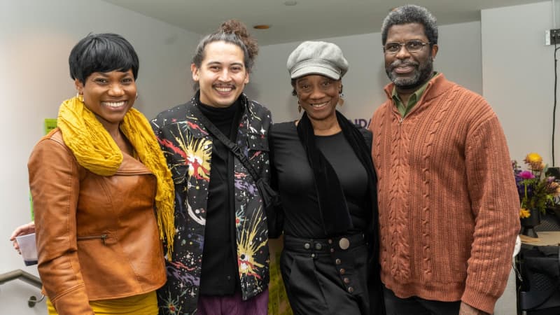 Director David Mendizábal and actor Stephanie Berry put their arms around two other people and smile for a group photo.