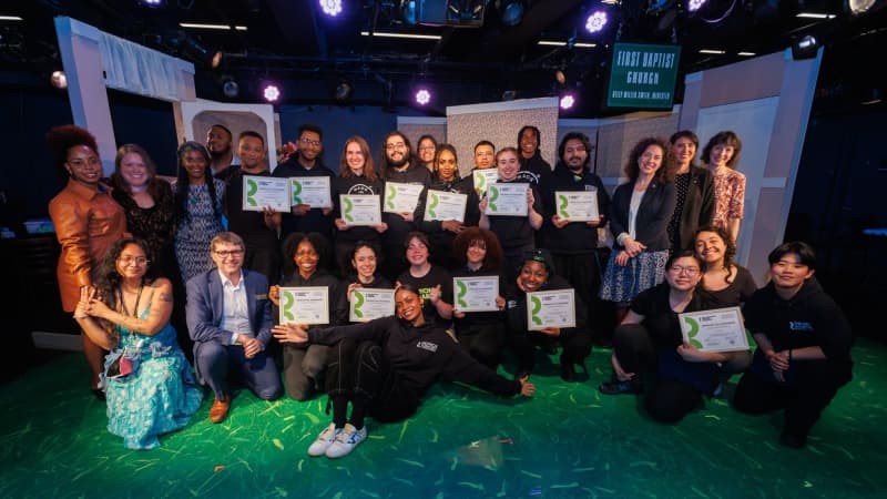 A group of TWDP fellows clump together for a group photo where they all hold up their certificates.