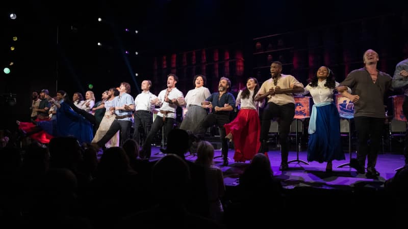 The cast of PIRATES OF PENZANCE links arms at the front of the stage and does a kick line.