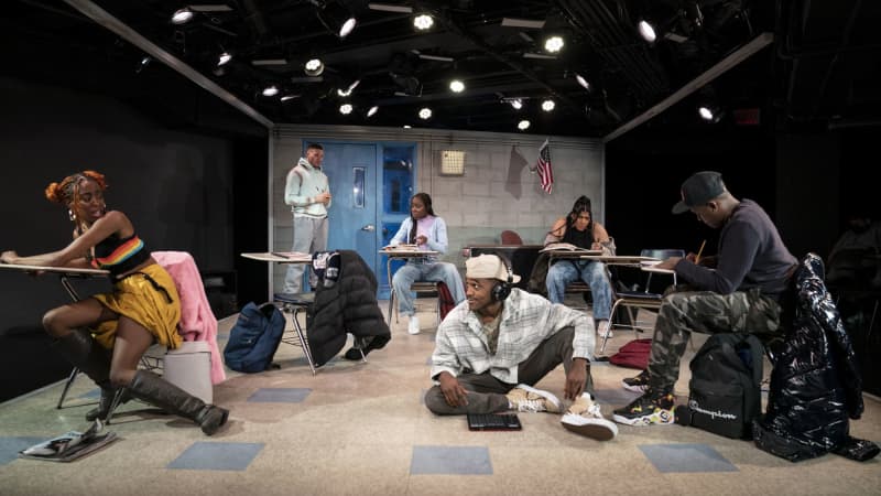 Six highschoolers darted around a classroom set on stage. Some sit at desks, some stand, some chill on the floor.