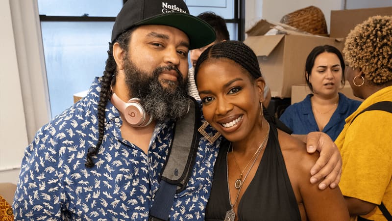 Playwright Nathan Alan Davis and actor Jessica Frances Dukes pose their arms around each other for a photo in the rehearsal studio.