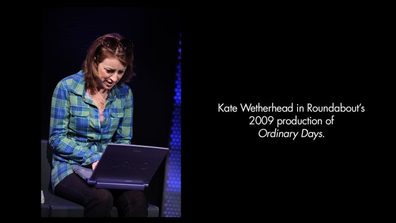 Kate Wetherhead in Roundabout's 2009 production of Ordinary Days. A light-skinned woman with short, brown hair held back by a pair of large sunglasses types into a laptop.