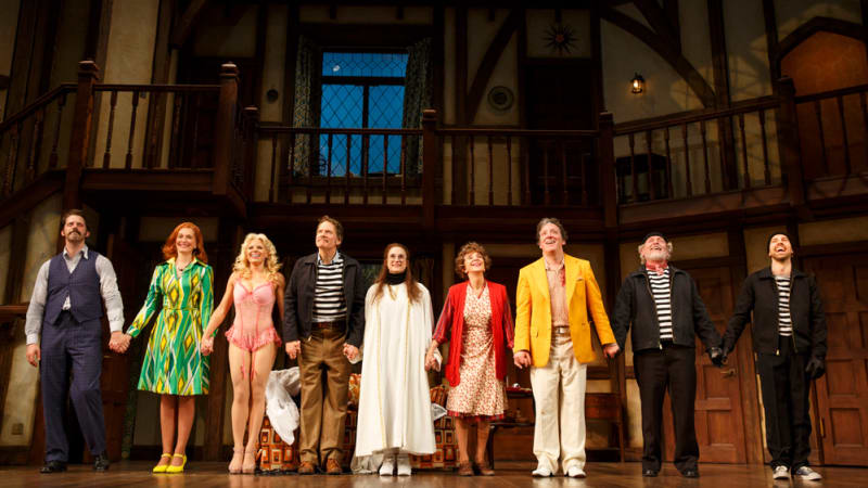 A group of eclectic actors stand at the front of the stage holding hands during the curtain call.