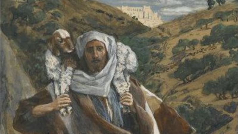 A light-skinned man in a brown tunic and white headscarf climbs down rocks with a sheep held around his neck.