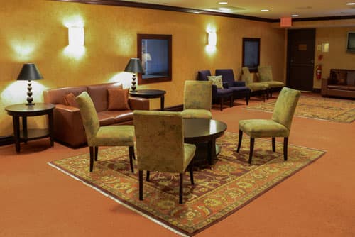 Image of the Langworthy Lounge in the Todd Haimes Theatre with 4 chairs around a coffee table. 