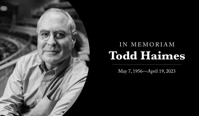 Black and white photo of Todd Haimes sitting in the balcony of a theatre next to text that reads, In Memoriam. Todd Haimes. May 7, 1956 to April 19, 2023