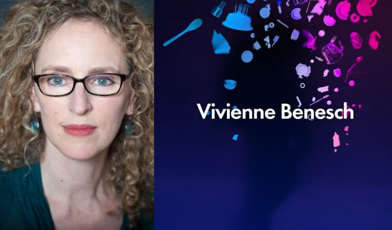 Vivienne Benesch, a light-skinned woman with curly, blonde hair wears black glasses, a teal shirt, and teal earrings.