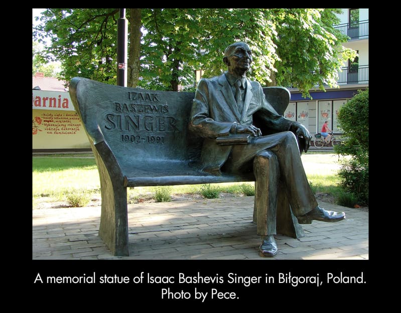 A memorial statue of Isaac Bashevis Singer in Biłgoraj, Poland. Photo by Pece. A textured metal bench with a life-size sculpture of Isaac Bashevis Singer seated on it. 