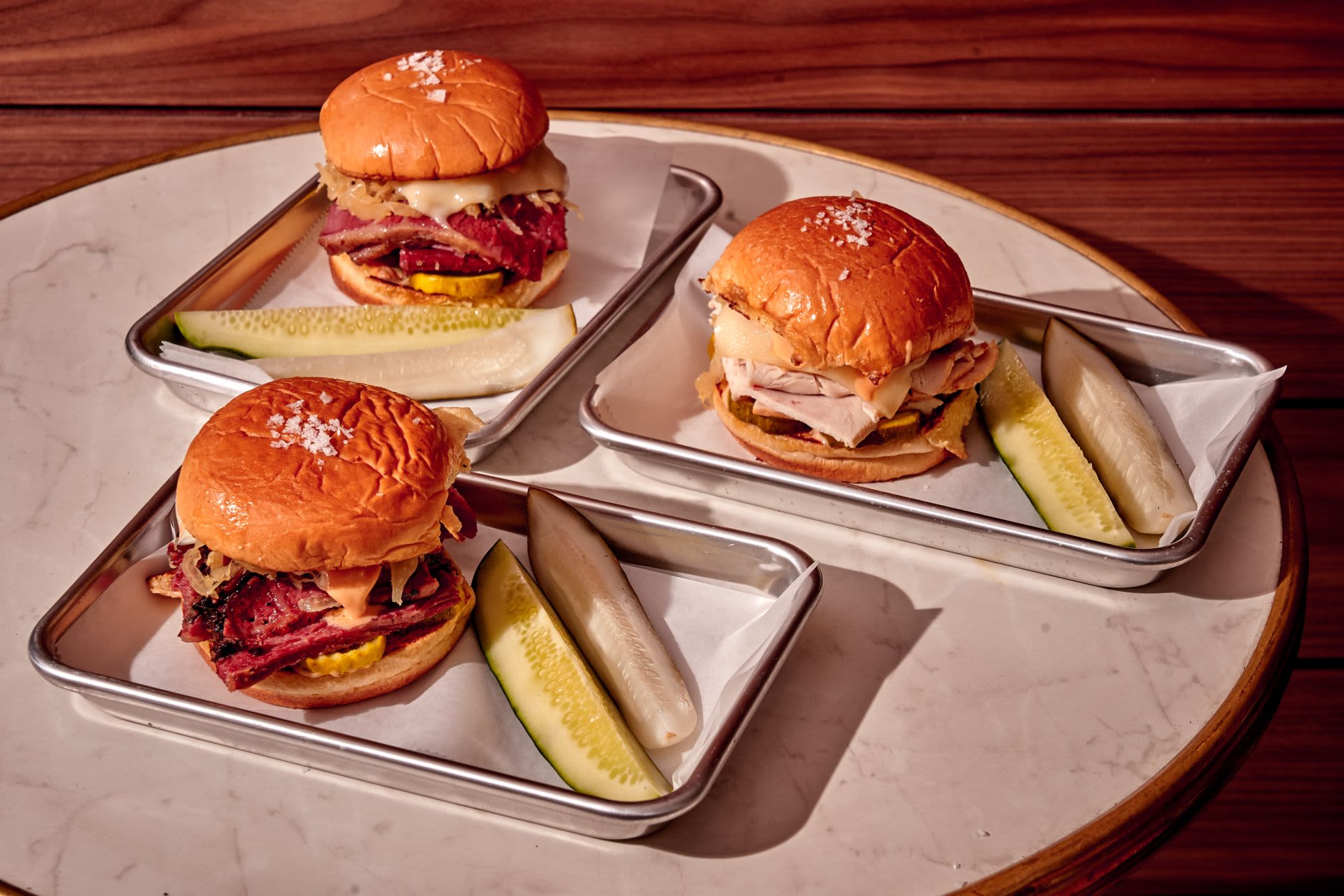 Three sandwiches with pickles from the Brooklyn Deli
