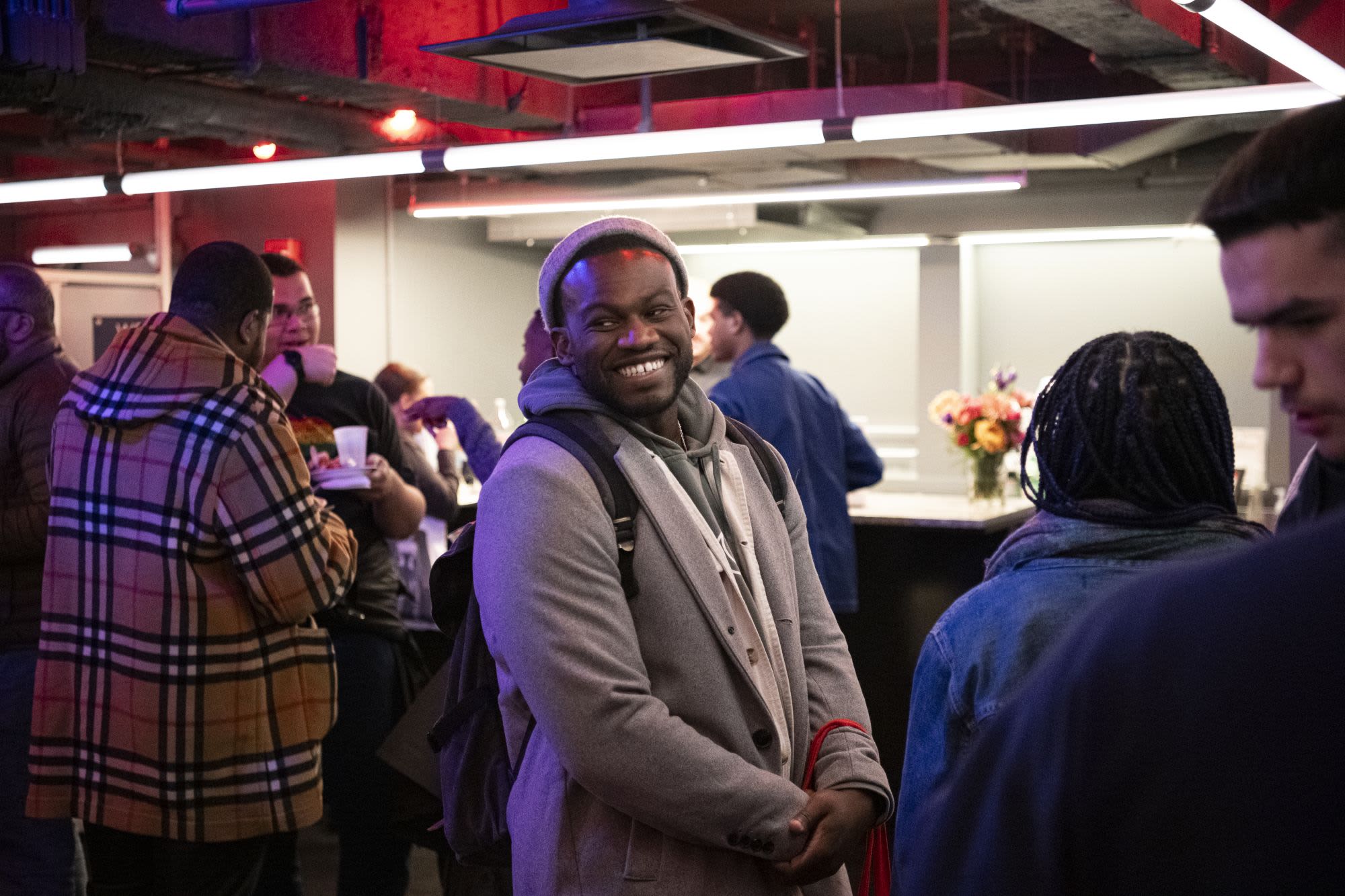 A guest smiles broadly while mingling at Covenant: Black Queer Theatre Night at Roundabout Theatre Company.


