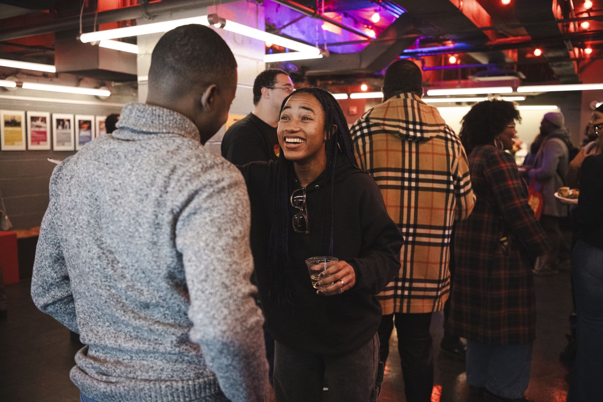 A guest laughs warmly during a conversation at Covenant: Black Queer Theatre Night at Roundabout Theatre Company.

