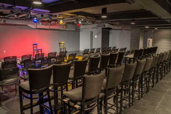 Black Box theatre with chairs set up facing a makeshift stage with two empty chairs