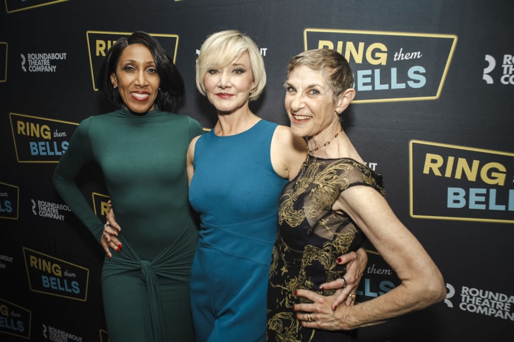 A group of people in formal attire pose on the red carpet.