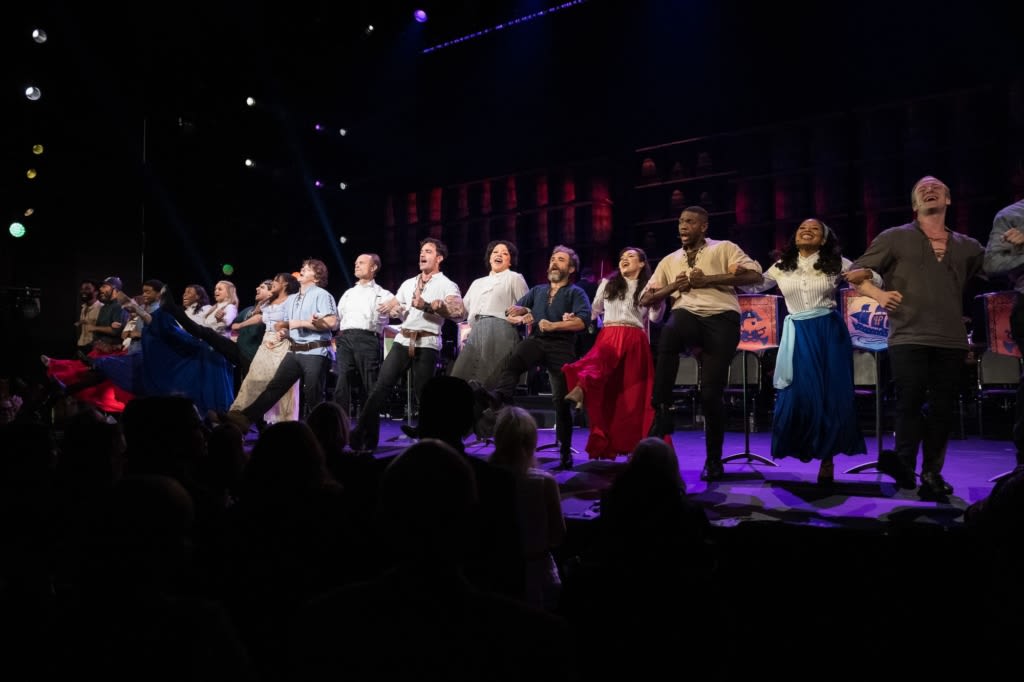 The cast of PIRATES OF PENZANCE links arms at the front of the stage and does a kick line. Photo by Marcus Middleton.