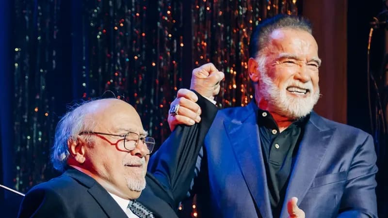 Danny DeVito and Arnold Schwarzenegger in formal attire. 