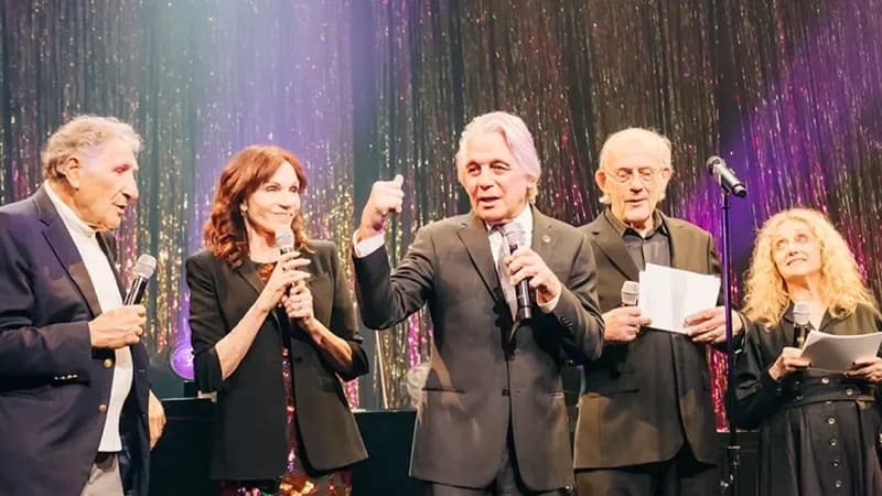 Tony Danza and the cast of the TV show Taxi stand on stage together in formal attire.