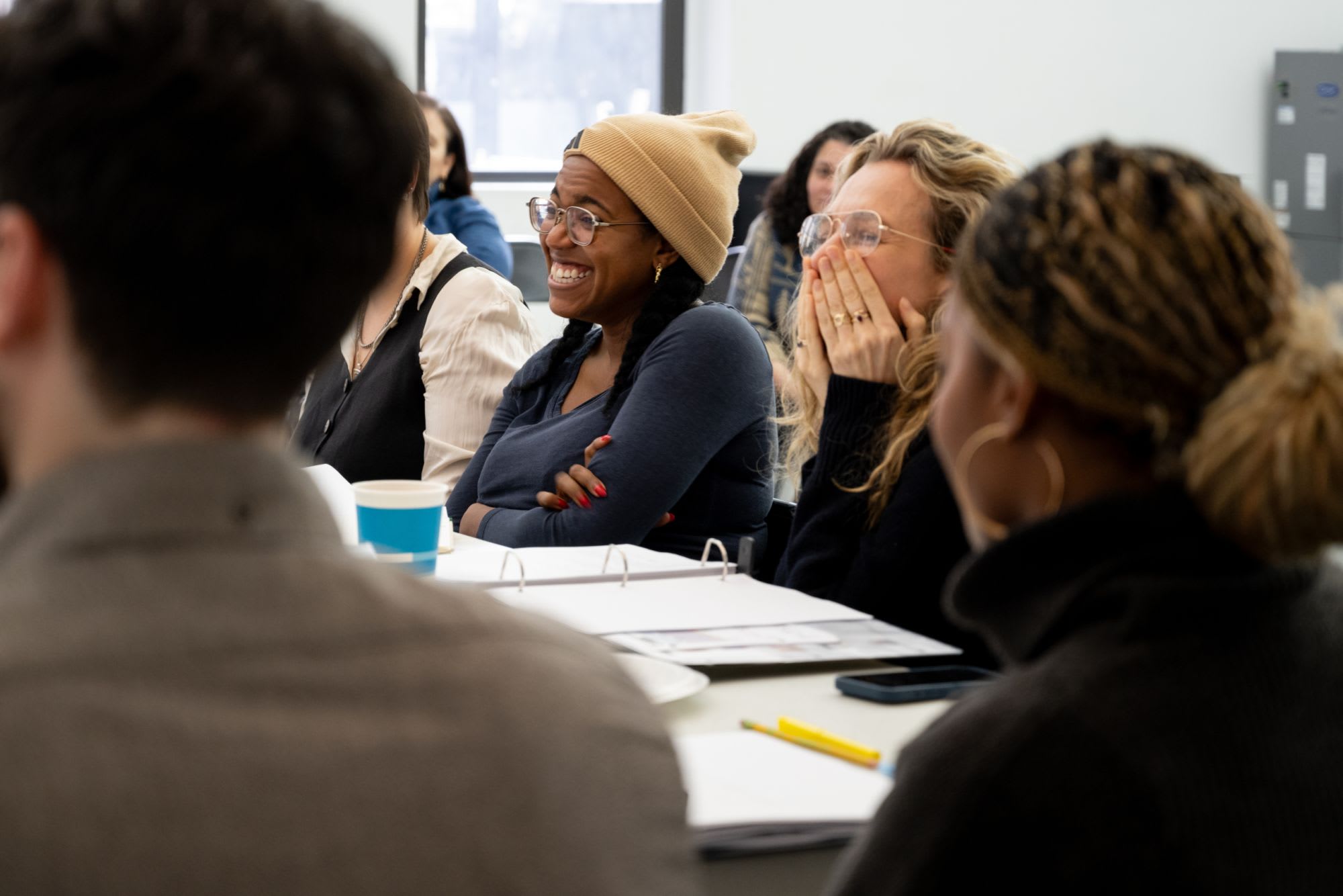 A director and playwright laugh during a table read.