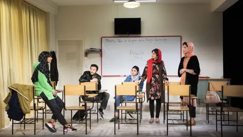 The cast of ENGLISH in the 2022 production. Four people sit in a classroom.