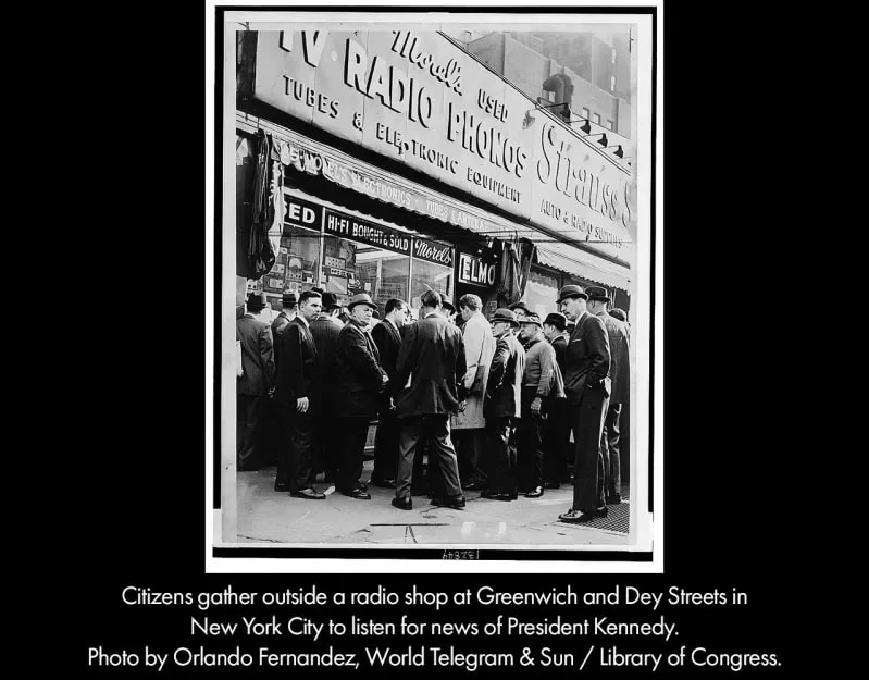 Citizens gather outside a radio shop at Greenwich and Dey Streets in New York City to listen for news of President Kennedy.