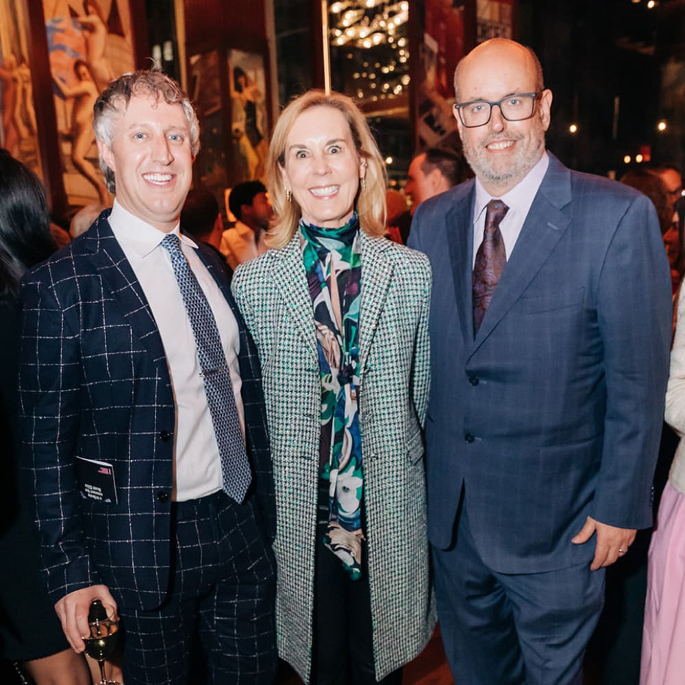 Three people posing for a picture in formal wear