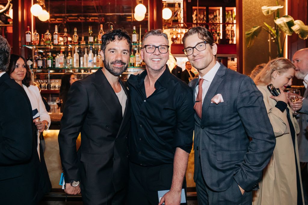 Three people posing for a picture in formal wear
