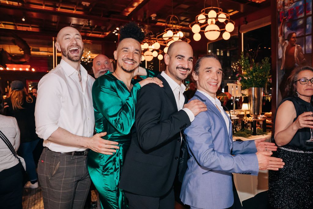Four people posing for a picture in formal wear.