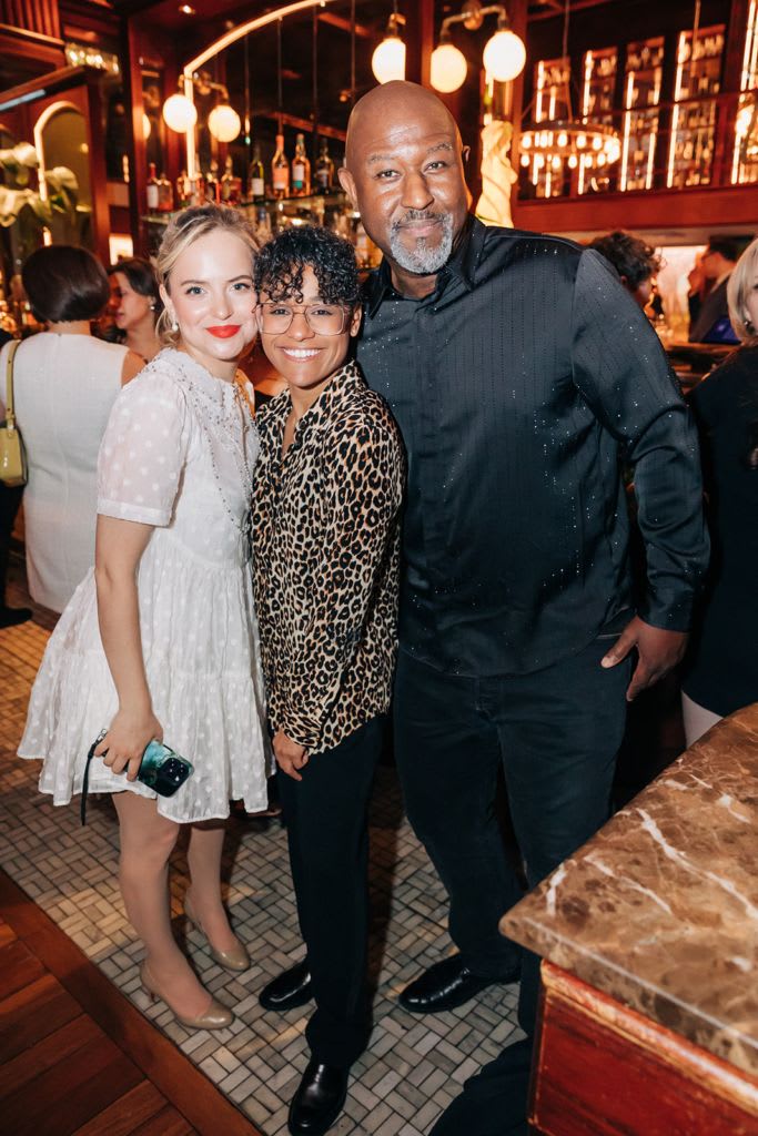Three people posing for a picture in formal wear
