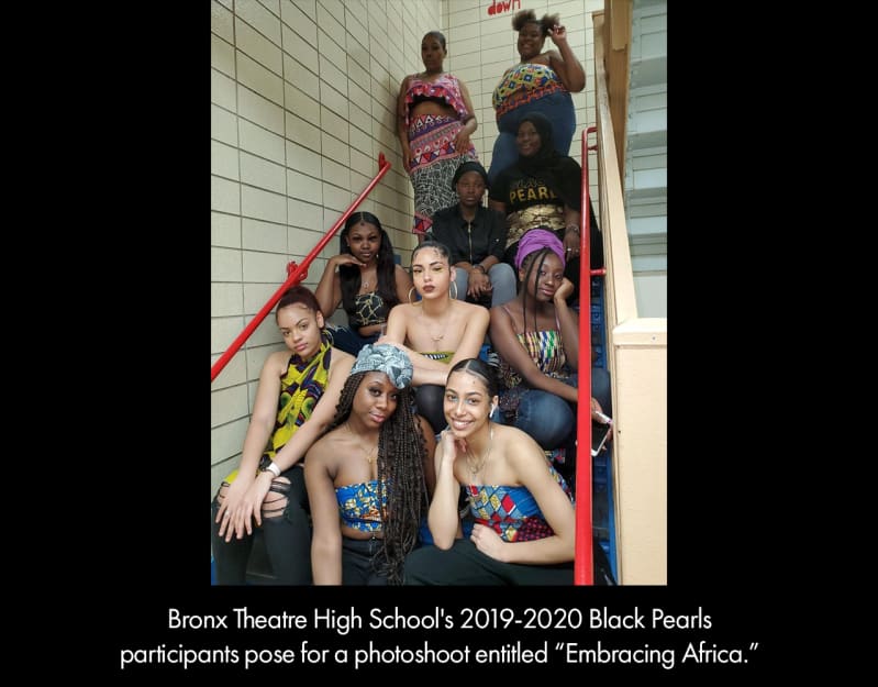 Bronx Theatre High School's 2019-2020 Black Pearls participants pose for a photoshoot entitled "Embracing Africa." Young women with medium or dark skin, wearing shirts made from multi-colored fabric.