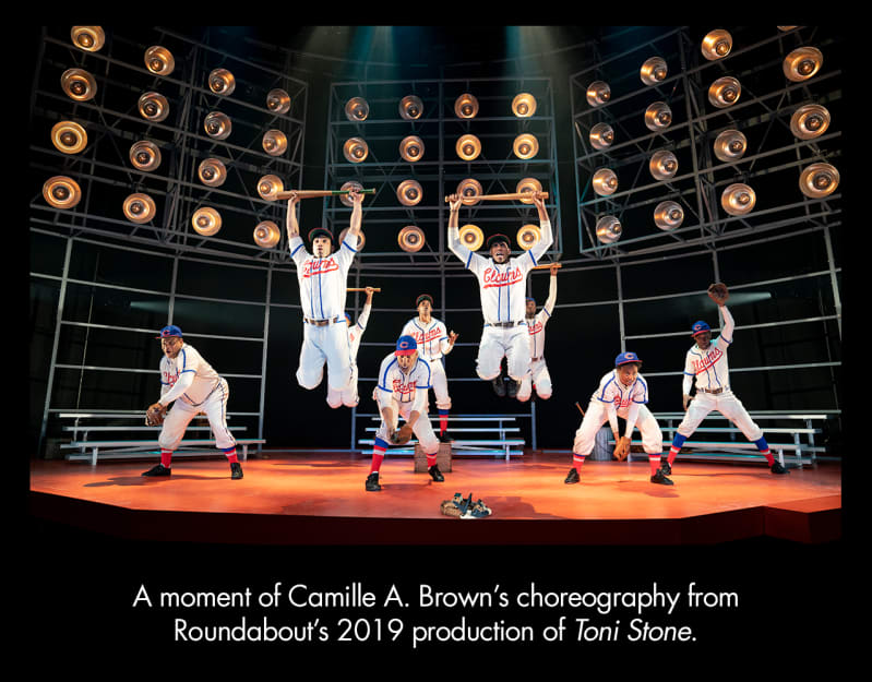 A moment of Camille A. Brown's choreography from TONI STONE. Five dark-skinned people in white baseball uniforms pose as if fielding a ball. Four others are suspended mid-jump holding baseball bats.