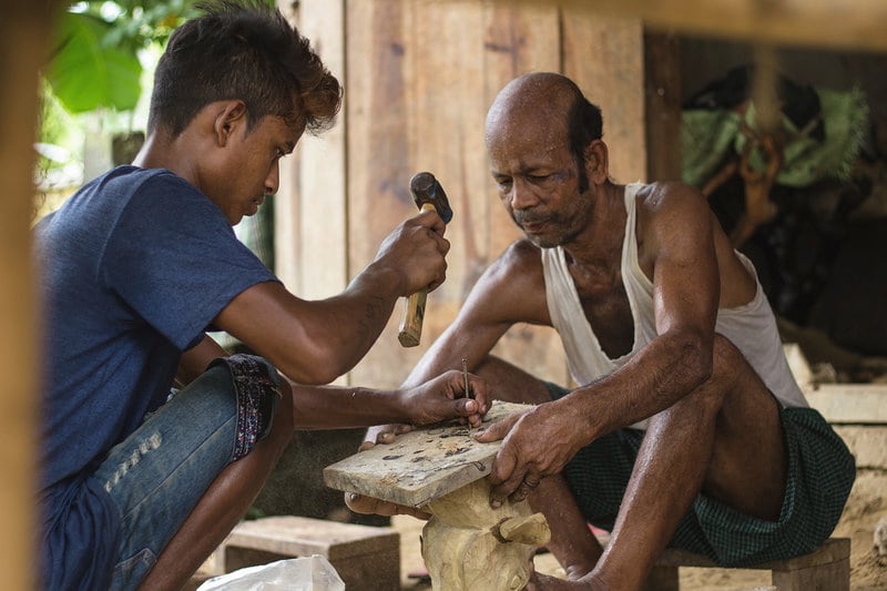 Woodcarver Kushal Das (right) and his assistant Deepak Bora at work in Das’s woodcarving workshop-cum-shop at Rajabari, Kaziranga. Photo: Sumit Das
