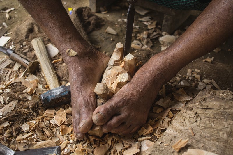 Kushal Das carving an eight-inch one-horned rhinoceros. It takes Das about one and a half hours to complete the carving. Photo: Sumit Das
