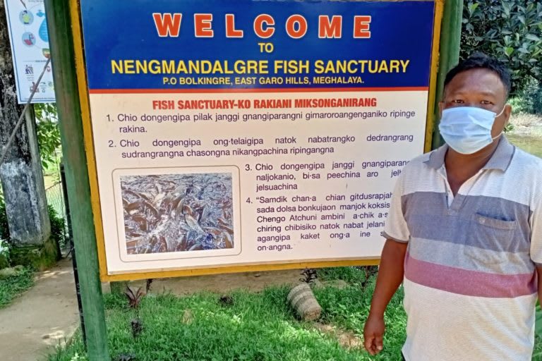 Rev. Jimmy Carter D. Sangma in front of the fish sanctuary. The impact of conservation has also had a socio-economic effect on the local community. Photo courtesy: Rev. D. Sangma