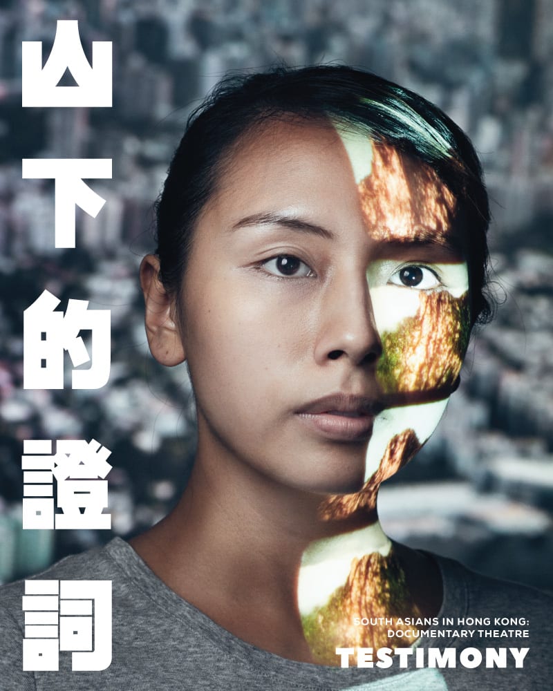 天台製作（Rooftop Productions）紀錄劇場作品《山下的證詞》（Testimony）的宣傳海報。畫面為演員李里莎（Arisa Yasaratne）的特寫人像，她神情平靜地凝視鏡頭。一道象徵香港山巒地貌的影像投影在她的左臉與頸部，隱喻了身份認同與土地的連結。背景為模糊的城市景觀，突顯了這部當代劇場作品對於在港南亞社群的深刻探索。