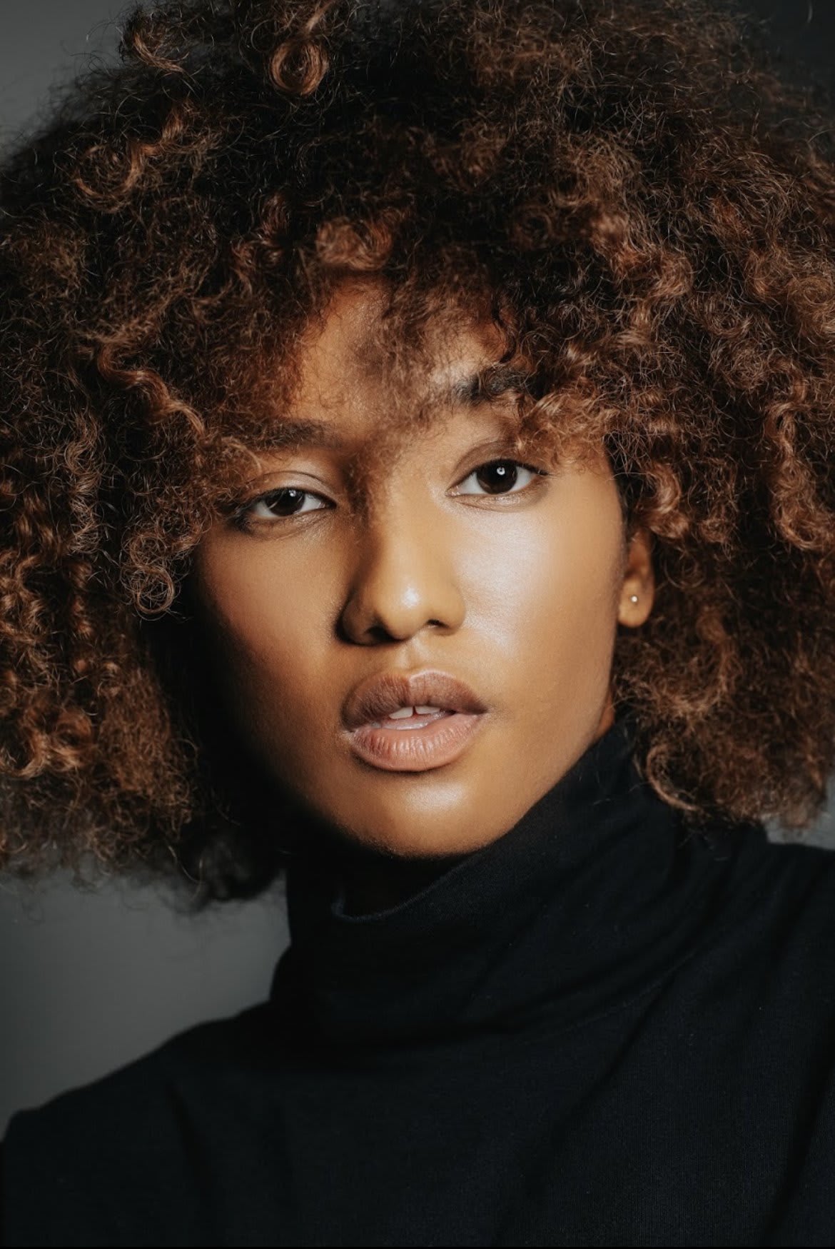 演員陳琬瑜的專業攝影棚人像照，在深色背景的襯托下，柔和的專業燈光細緻地捕捉了她的神韻與堅定的表情。這張照片展現了「天台製作」 (Rooftop Productions) 作為香港當代劇場領航者，對表演藝術高水準的專注與投入。形象照。