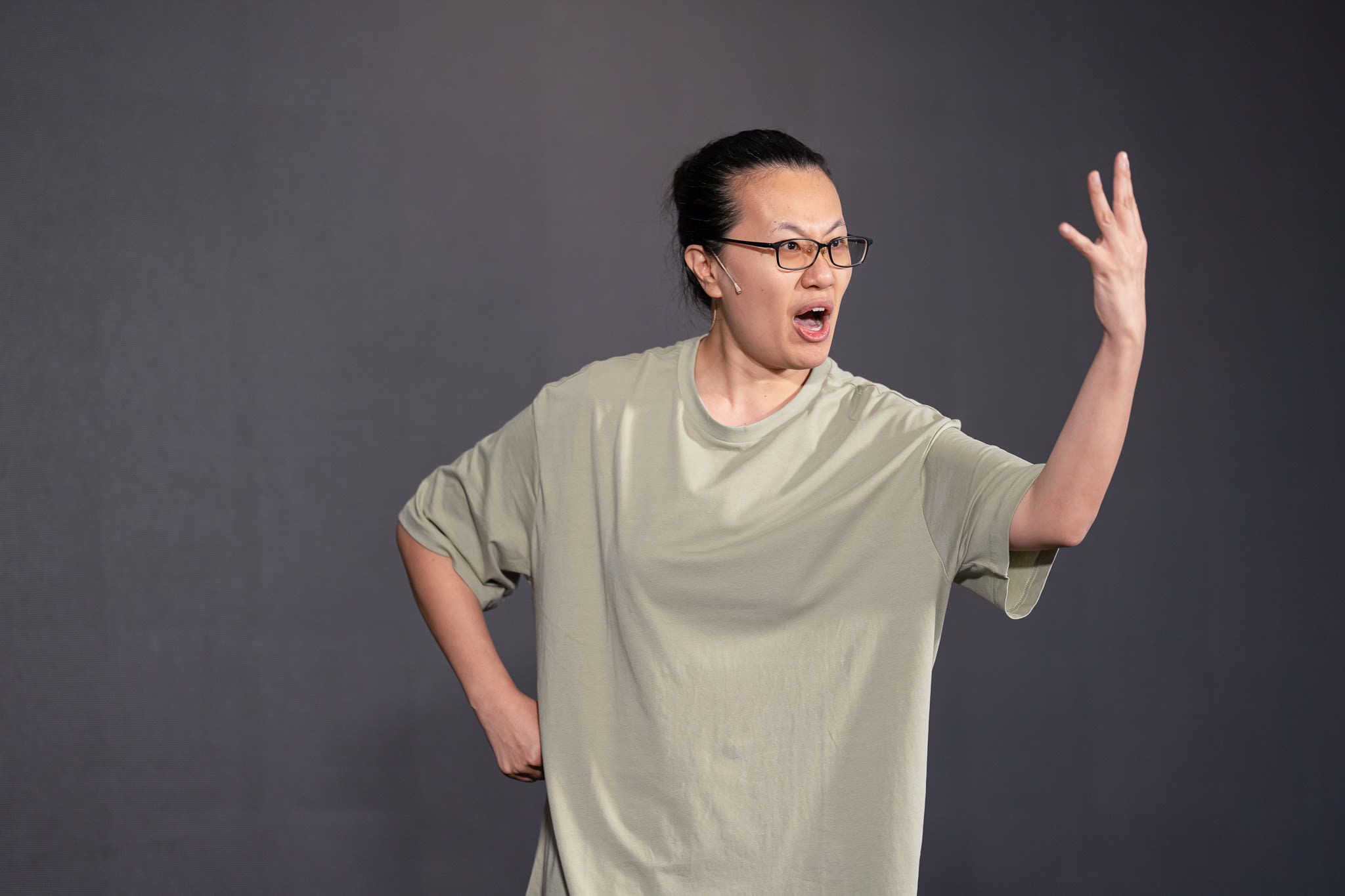 李婉晶於天台製作（Rooftop Productions）當代劇場作品《卡啦OK》中，展現充滿張力的舞台表演。在深灰色背景及冷峻的舞台燈光下，她以強而有力的肢體動作呈現角色的情緒，單手高舉，神態激昂地說道：「四員虎將齊站定」