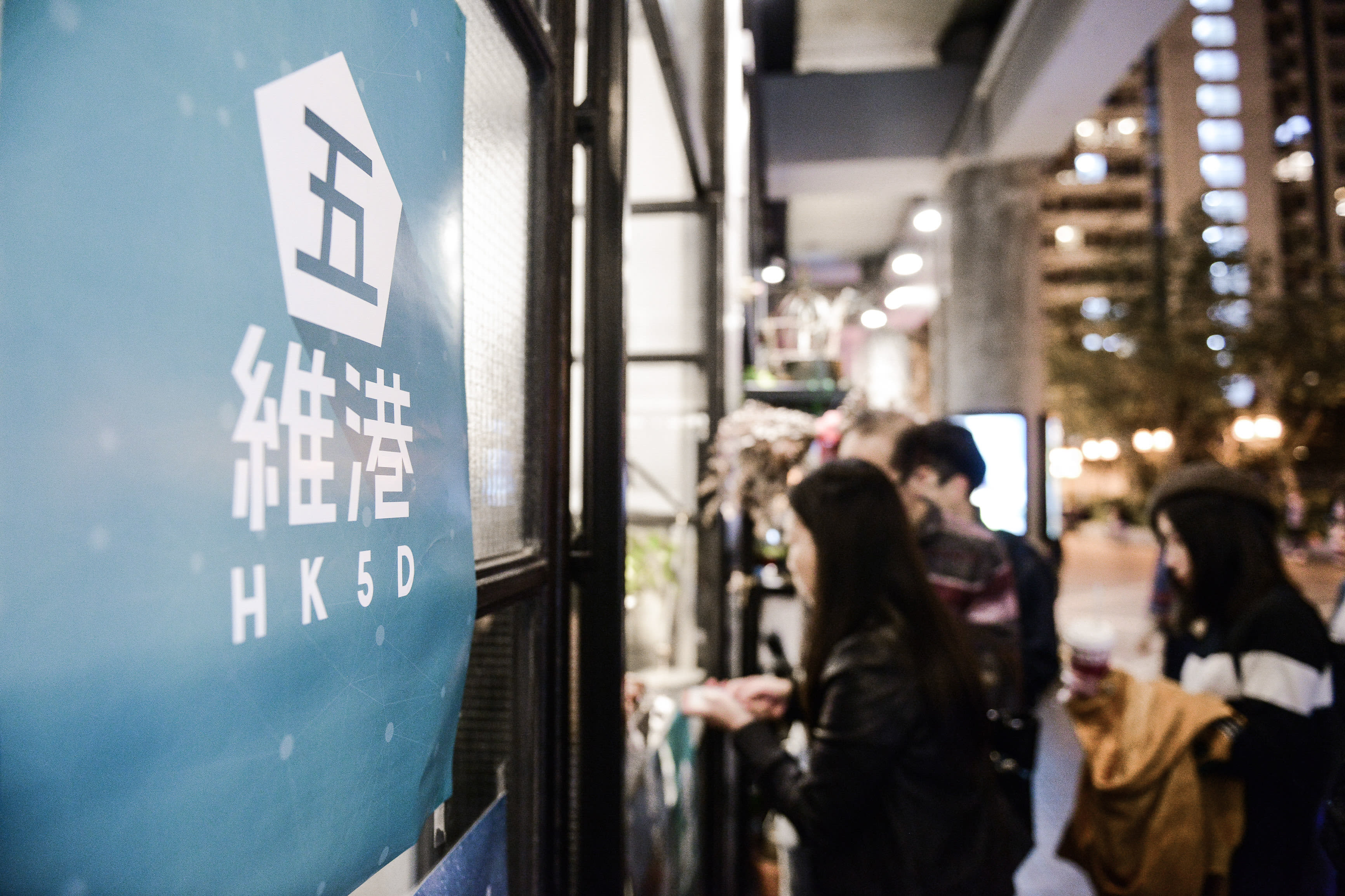 一張香港當代劇場製作《消失的海岸線》（Lost Shoreline）的宣傳告示特寫，上方印有劇目的「HK5D」標誌。背景中，觀眾在夜晚的演出場地外聚集，呈現出香港本土獨立劇場親密且充滿張力的現場氛圍。《消失的海岸線》。