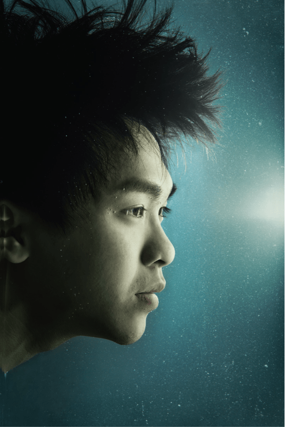 由天台製作（Rooftop Productions）呈獻的當代香港劇場劇照，演員吳景隆的戲劇性特寫人像。他以側臉示人，彷彿潛入水中，髮絲向上飄浮，呈現出香港前衛劇場特有的超現實與空靈美學。冷色調的燈光襯托出他沉思的神情，周圍漂浮著細小的氣泡，氛圍靜謐而深刻。宣傳照。