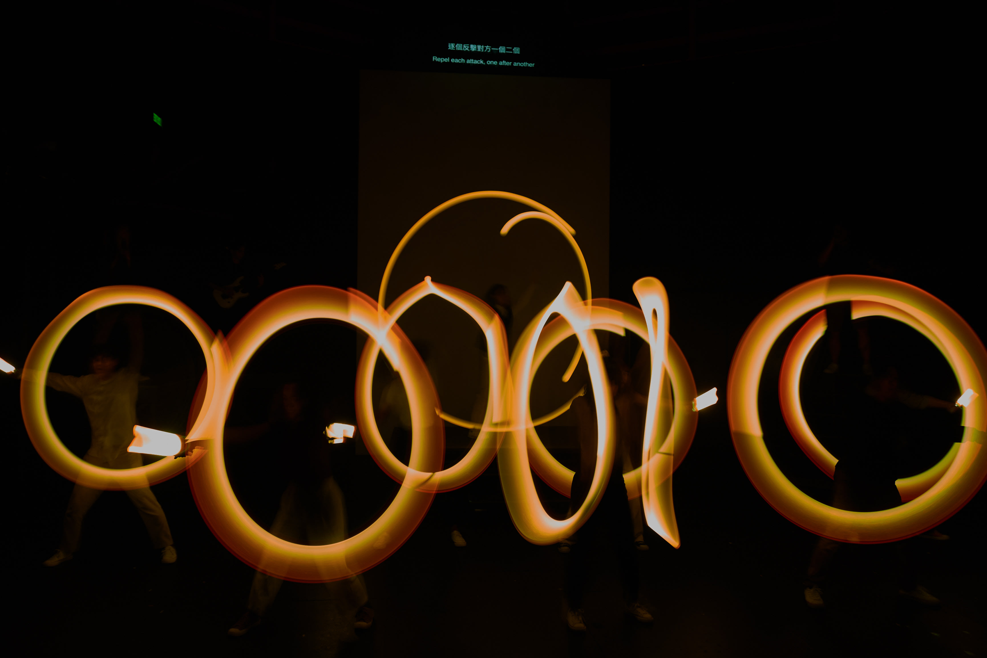 Performers utilize light-painting to embody the transformative process of maturity. As the shadows shift, they declare: 'When I meet a monster, I instantly grow.'