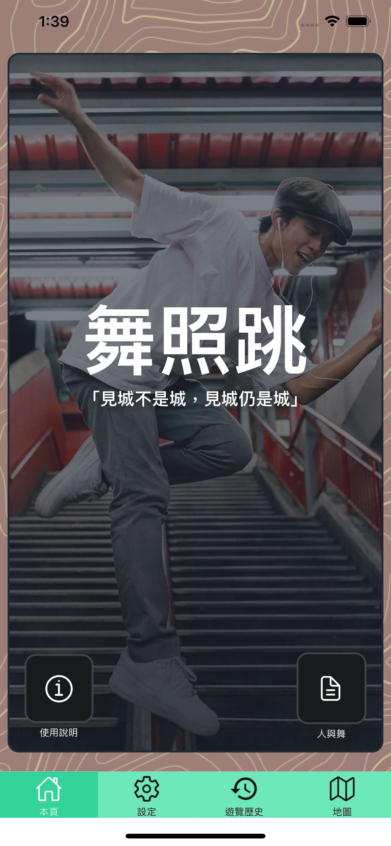 這是《舞照跳》（We Still Dance）應用程式的介面截圖。背景展示了一位現代舞者在樓梯間躍起的動態全身照，他身穿白色T恤、灰色長褲並戴著平頂帽，充分體現了天台製作（Rooftop Productions）那種充滿當代劇場張力與肢體自由的藝術風格。應用程式介面底部配有設定、瀏覽歷史及地圖等導航圖示，並設有「人與舞」的專項按鈕。「《舞照跳》——『見城不是城，見城仍是城』。」