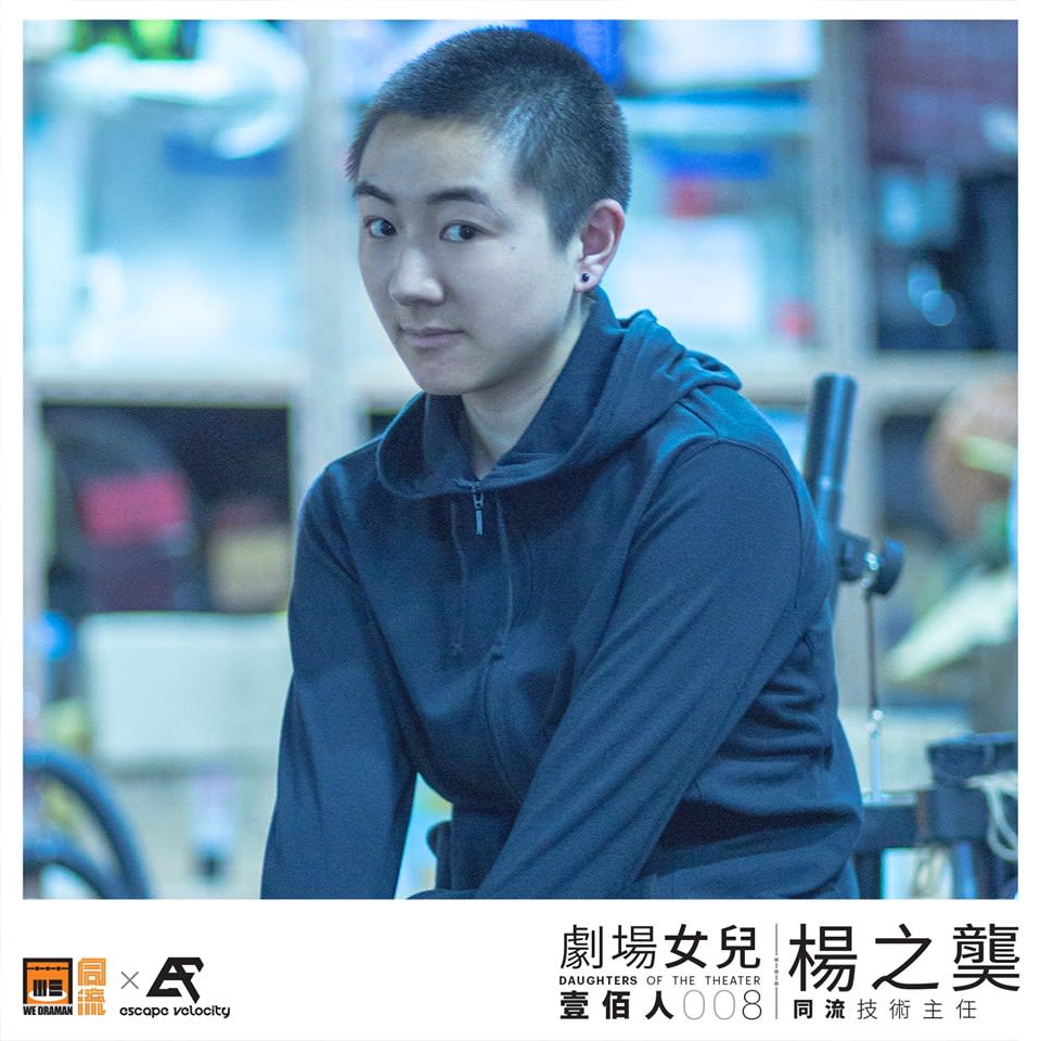 香港當代劇場團體「天台製作」技術主任楊之龑的專業人像照。照片中的她穿著深藍色連帽外套，直視鏡頭，神情自信且沉穩，背景為模糊的劇場工作空間。此影像為「劇場女兒」系列專題之一，旨在記錄於香港表演藝術幕後默默耕耘、成就劇場創作的女性專業人士。