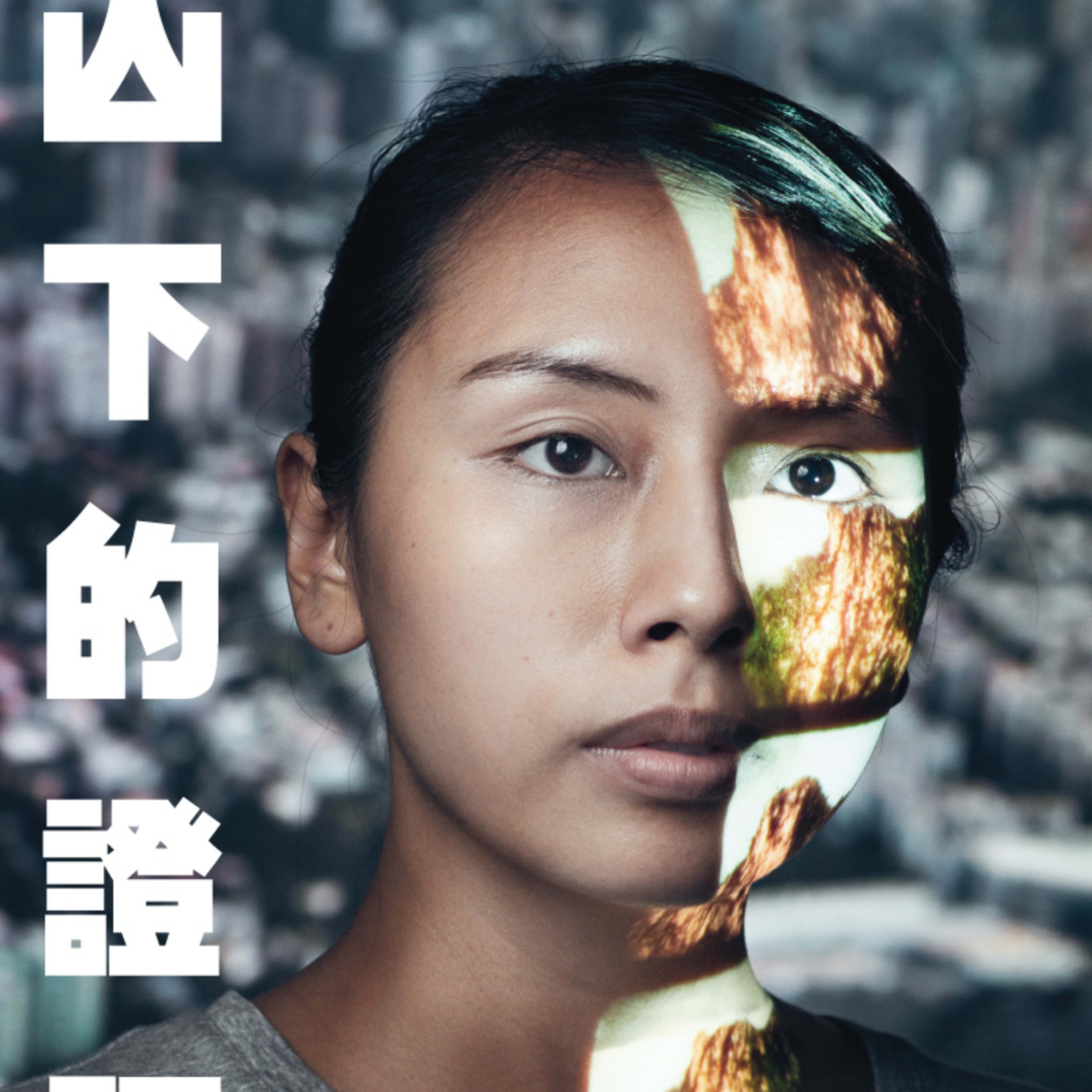 天台製作（Rooftop Productions）紀錄劇場作品《山下的證詞》（Testimony）的宣傳海報。畫面為演員李里莎（Arisa Yasaratne）的特寫人像，她神情平靜地凝視鏡頭。一道象徵香港山巒地貌的影像投影在她的左臉與頸部，隱喻了身份認同與土地的連結。背景為模糊的城市景觀，突顯了這部當代劇場作品對於在港南亞社群的深刻探索。