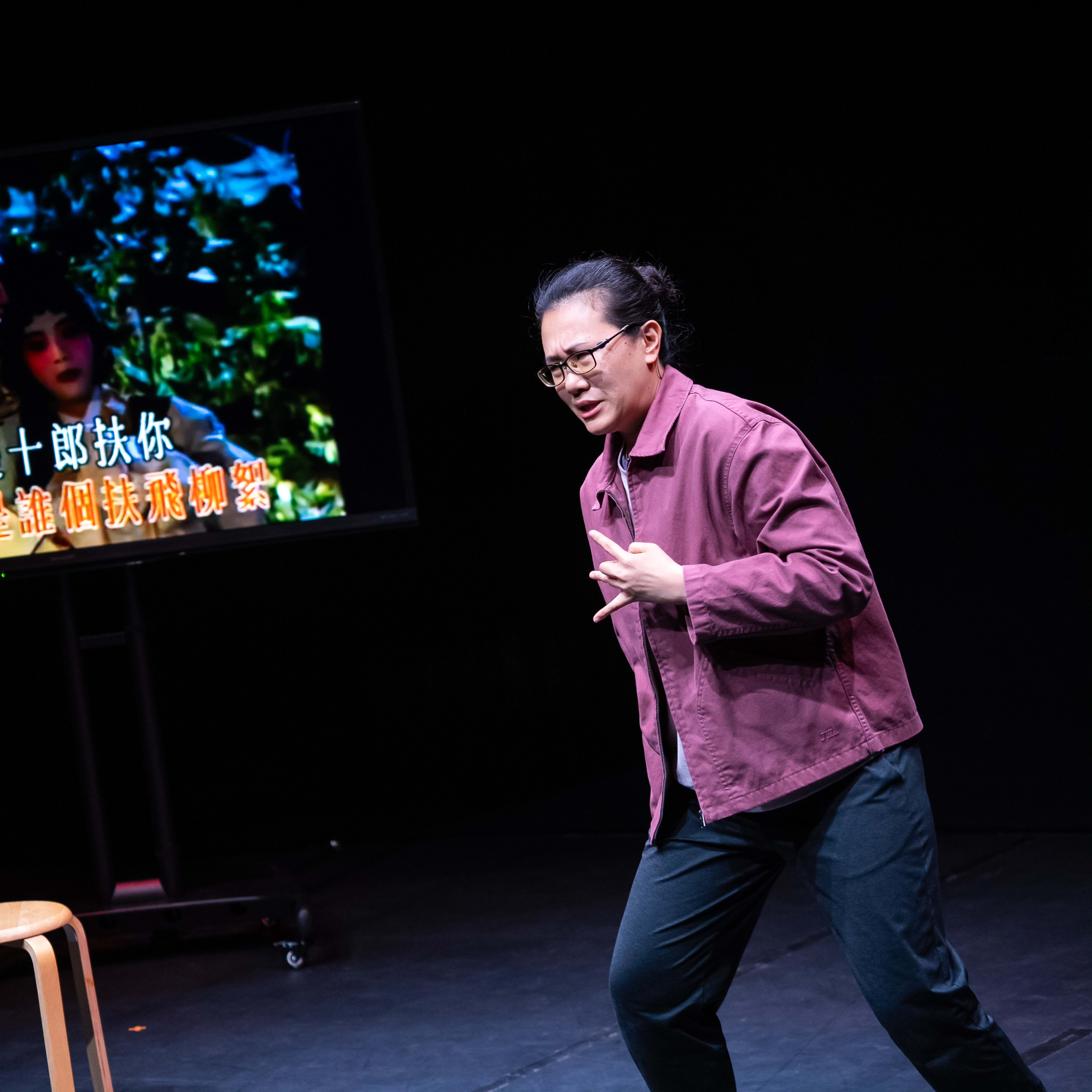 在天台製作的當代劇場作品《卡啦OK》中，演員李婉晶站在簡約的舞台上，身穿便裝，神情專注。她皺起眉頭，與身後電視屏幕上播放的經典戲曲角色霍小玉遙相呼應，舞台燈光營造出強烈的戲劇張力。表演者演繹道：「皺起眉頭，好像她就是霍小玉。」