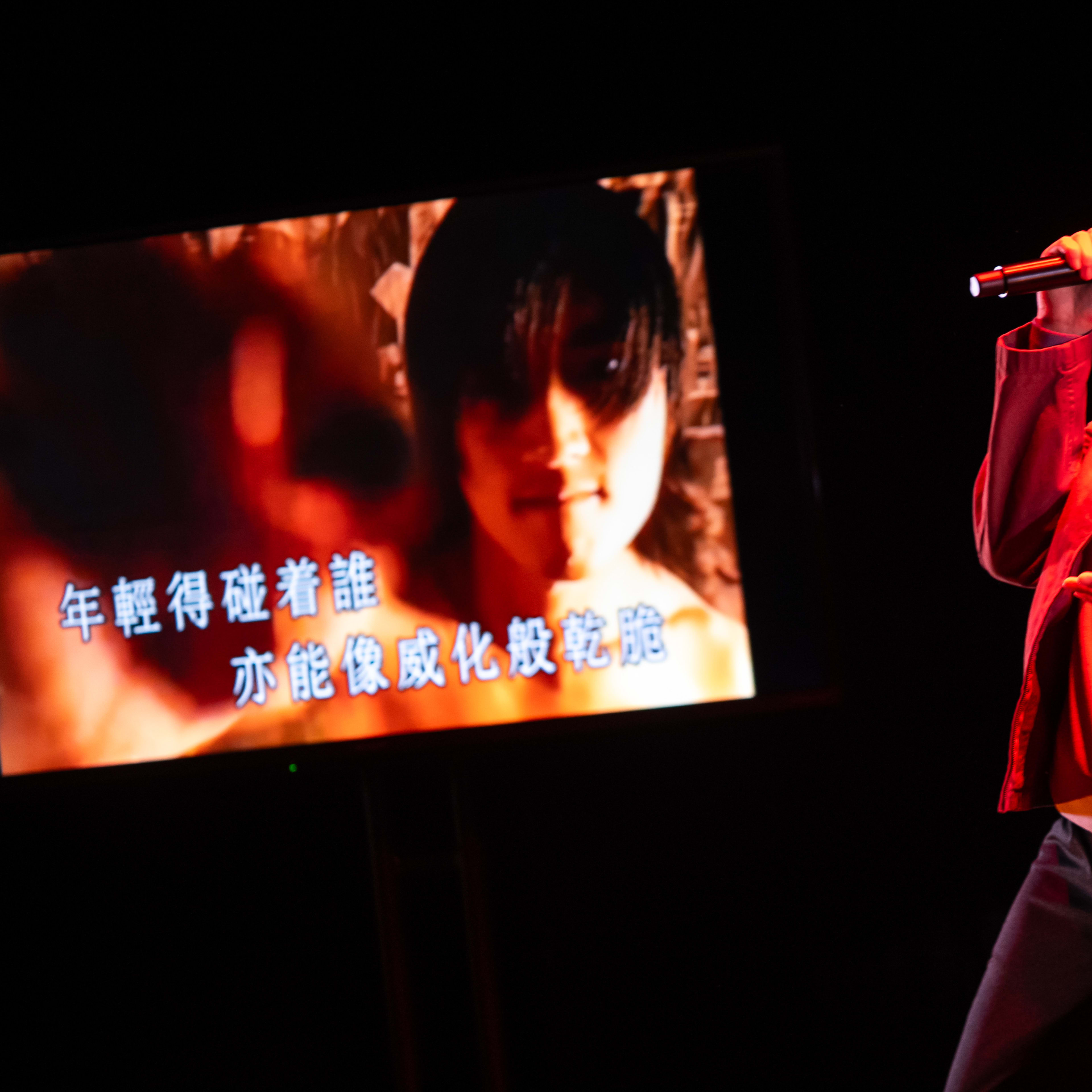 演員李婉晶於天台製作 (Rooftop Productions) 當代劇場作品《卡啦OK》中，呈現出一場充滿張力的演唱。舞台在濃郁的紅色燈光映襯下，李婉晶手持麥克風深情演繹，身後的螢幕則投射出一張青春洋溢的朦朧肖像，並伴有動態歌詞。這場香港舞台演出展現了極具感染力的現場氛圍，李婉晶唱道：「啊！年輕得碰着誰亦能像威化般乾脆。」